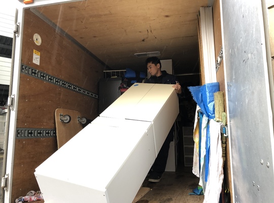 トラックに食器棚を積む写真