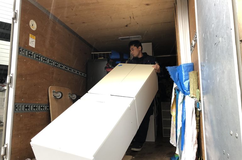トラックに食器棚を積む写真